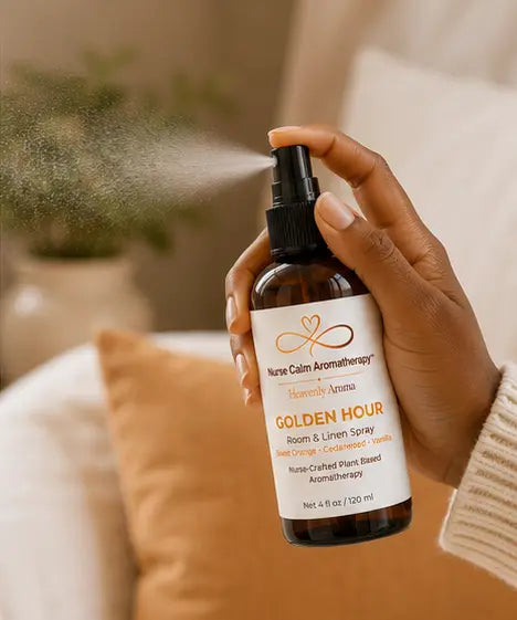 Hand using Golden Hour Room & Linen Spray to refresh a room with a botanical mist.