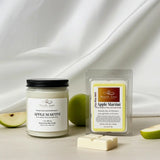 Jar and wax melt labeled 'Apple Martini' on a white fabric background