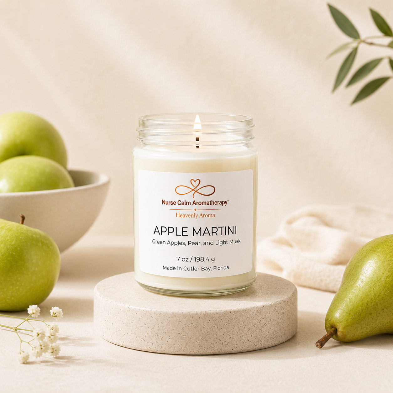 Candle labeled 'Apple Martini' with green apples and a pear on a neutral background
