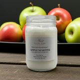 Candle in a jar labeled 'Apple Martini' with apples in the background