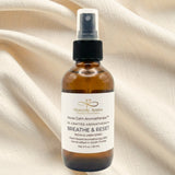 Bottle of Heavenly Aroma 'Breathe & Reset' room and linen spray on a beige fabric background