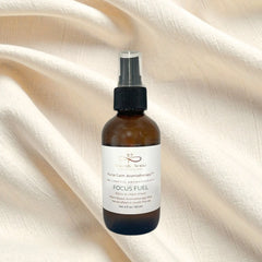 Brown spray bottle labeled 'Focus Fuel' on a beige fabric background