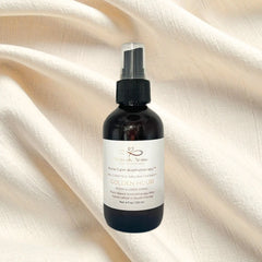 Black bottle with a white label on a beige fabric background