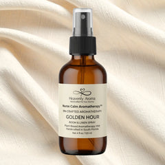 Brown bottle of Heavenly Aroma Golden Hour aromatherapy spray on a beige fabric background