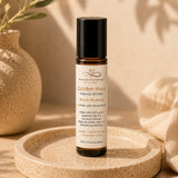 Essential oil roller bottle labeled 'Golden Hour' on a cork tray with a natural background