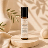 Roll-on bottle of 'Golden Hour' essential oil roller on a wooden platform with a neutral background