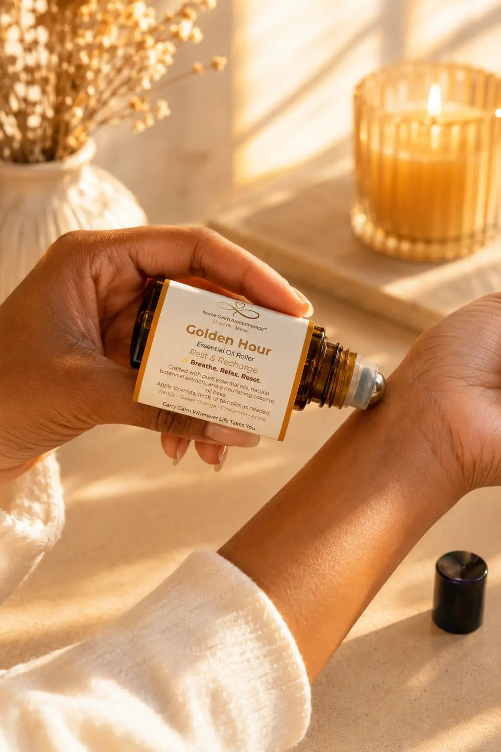 Applying Golden Hour essential oil roller to the wrist as part of a calming self-care ritual.