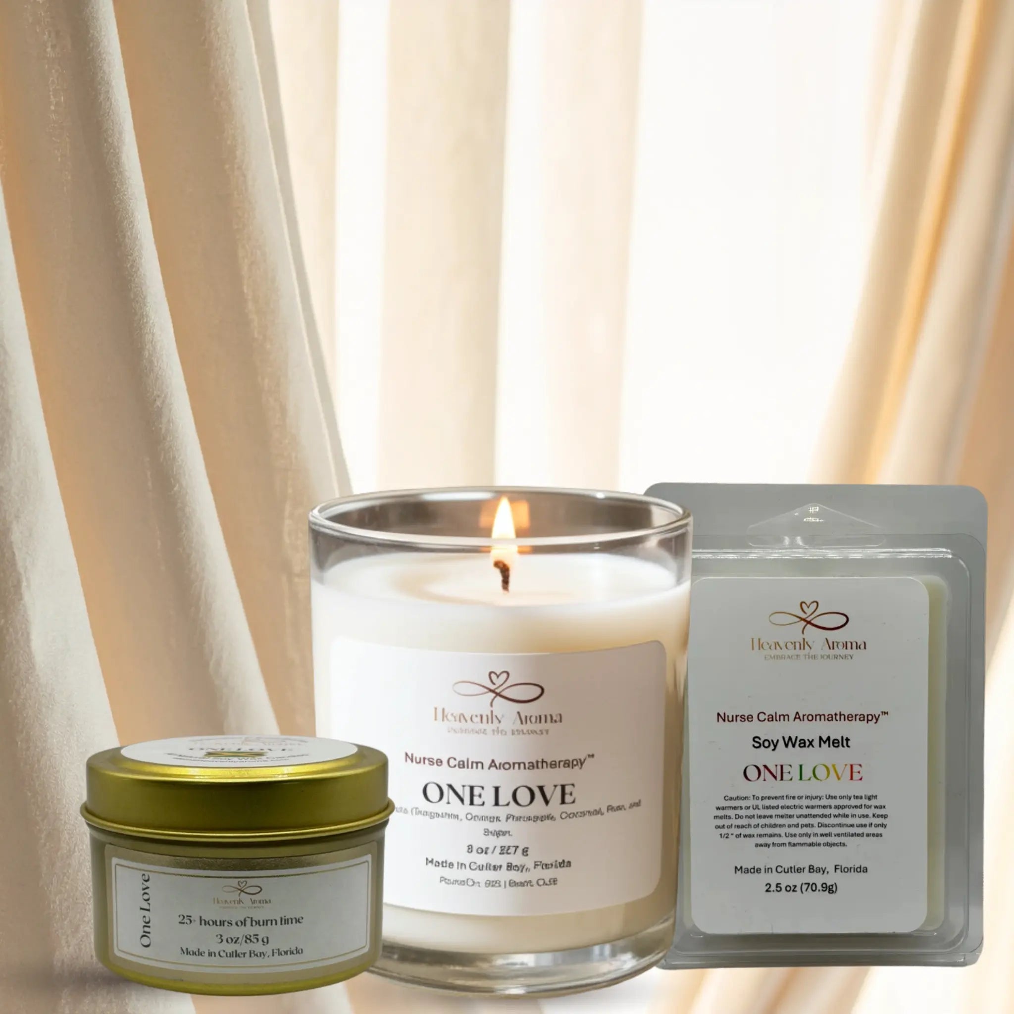 Candle and wax melts with 'One Love' packaging in front of a neutral curtain background