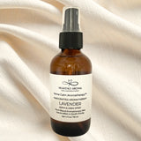 Brown spray bottle with a label on a beige fabric background