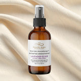 Brown bottle of Heavenly Aroma Lavender Elixir on a beige fabric background