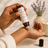 Person applying Lavender Elixir Essential Oil Roller to the wrist as part of a calming aromatherapy self-care ritual.