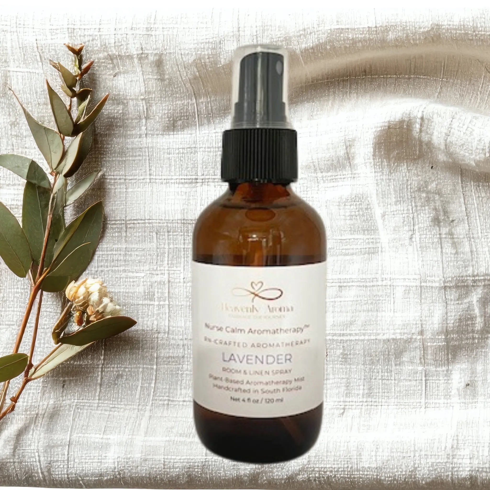 Brown glass bottle with black spray nozzle on a textured beige fabric background