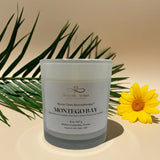 Candle labeled 'Montego Bay' with a yellow flower and green leaves on a beige background