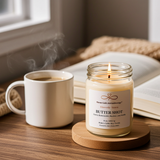 Butter Shot soy candle burning next to a steaming coffee mug for a cozy self-care moment.