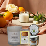 Candles and tins with 'ONELOVE' branding on a table with fruits and flowers.