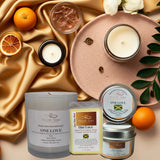 Collection of candles and scented products on a decorative surface with oranges and flowers.
