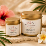 Close-up of the One Love Travel & Glow bundle highlighting reusable gold soy candle tins with tropical citrus, pineapple, coconut, rum, and sugar fragrance notes.
