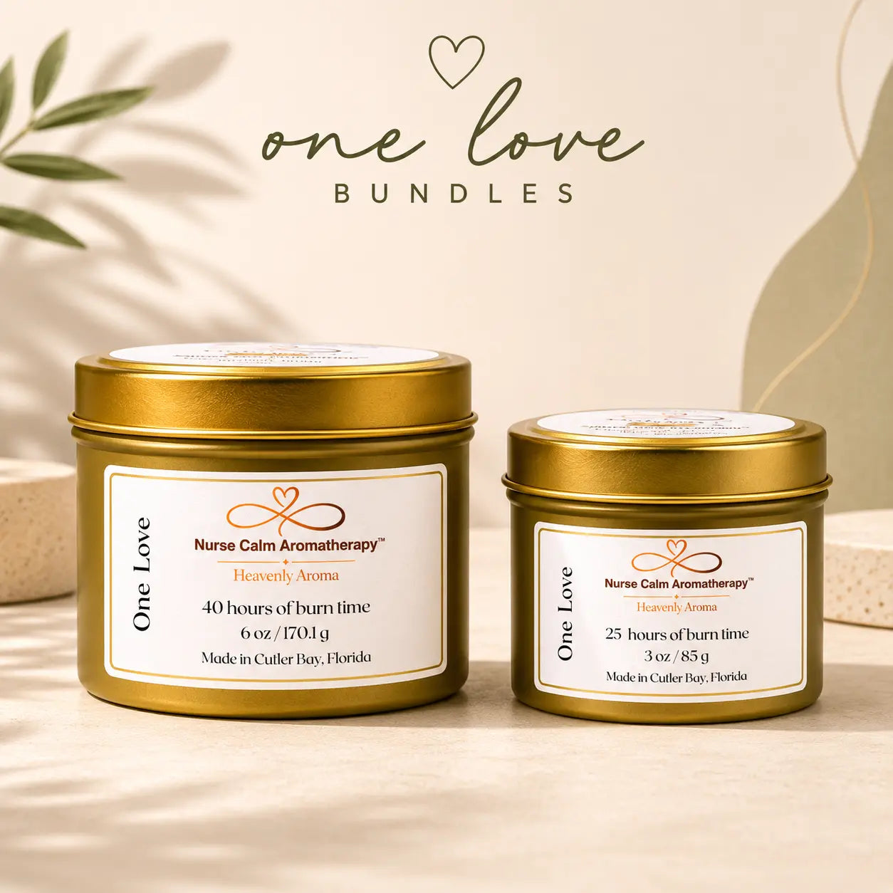 Two candles in gold tins with 'One Love' branding on a neutral background