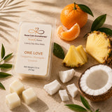 Flat lay featuring fresh tangerines, pineapple, coconut, and tropical botanicals representing the fragrance inspiration for One Love.