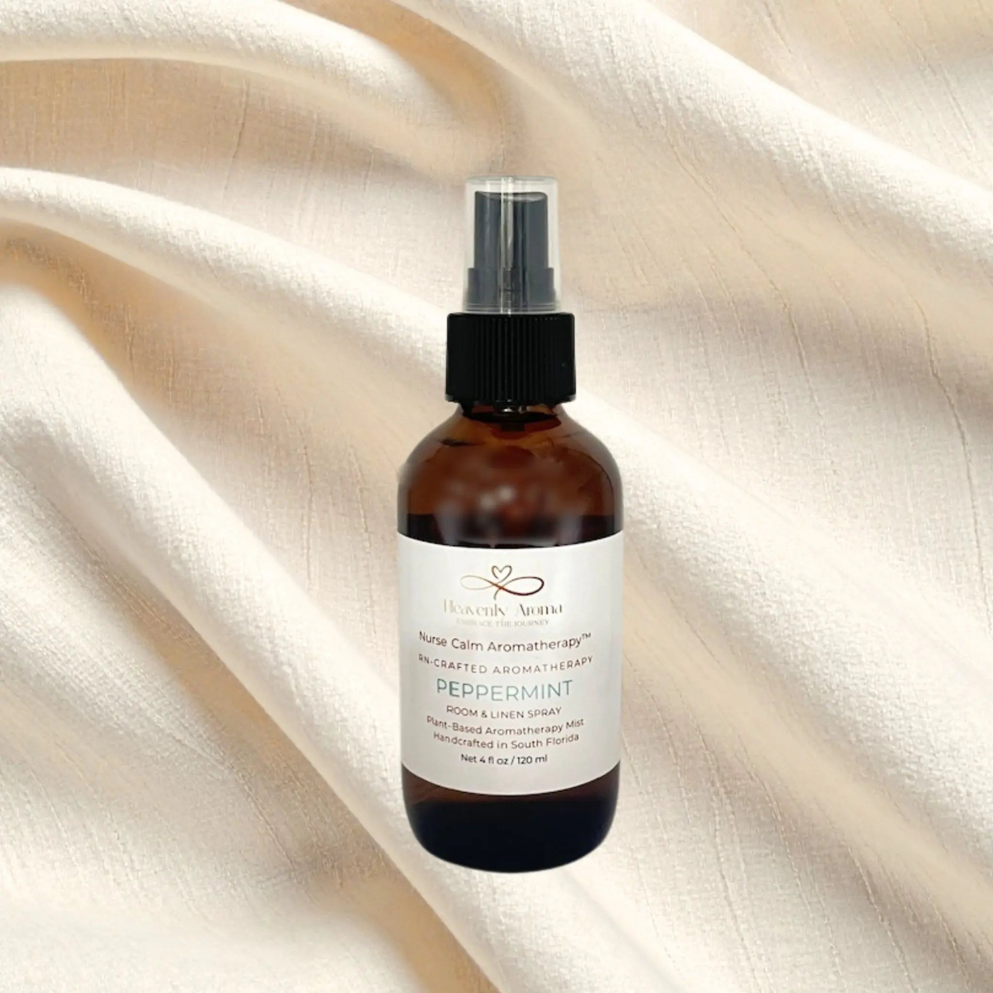 Aromatherapy spray bottle labeled 'Peppermint' on a beige fabric background