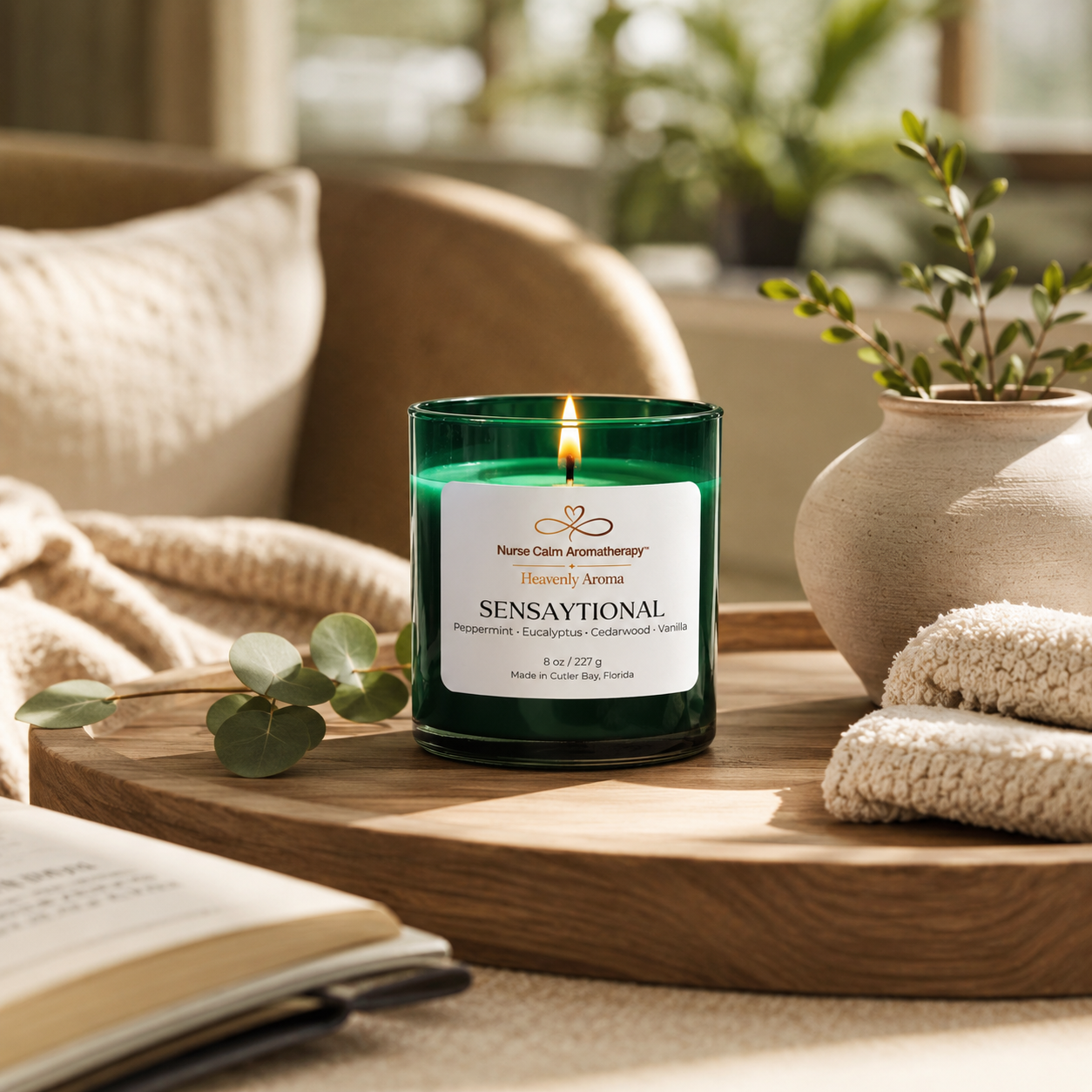Candle labeled 'Sensaytional' on a wooden table with a cozy indoor setting.
