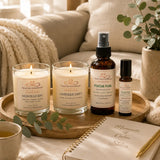 Signature Moments wellness bundle styled in a cozy self-care setting with handcrafted soy candles, Focus Fuel aromatherapy products, tea, and a journal.