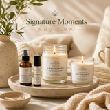 Soft neutral lifestyle scene featuring the Signature Moments candle bundle by Nurse Calm Aromatherapy™, including luxury soy candles, a room and linen spray, and an essential oil roller arranged on a stone tray with warm natural lighting and botanical accents.