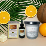 A display of natural products including candles, a soap bar, and a bottle with fruits and leaves on a beige background.