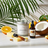 Cosmetic products including a candle, bottle, and other items on a surface with a coconut and orange in the background.