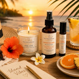 Tropical Escape wellness bundle styled in a tropical-inspired self-care setting with One Love candle, Sunset Escape aromatherapy products, fresh citrus, and island décor.