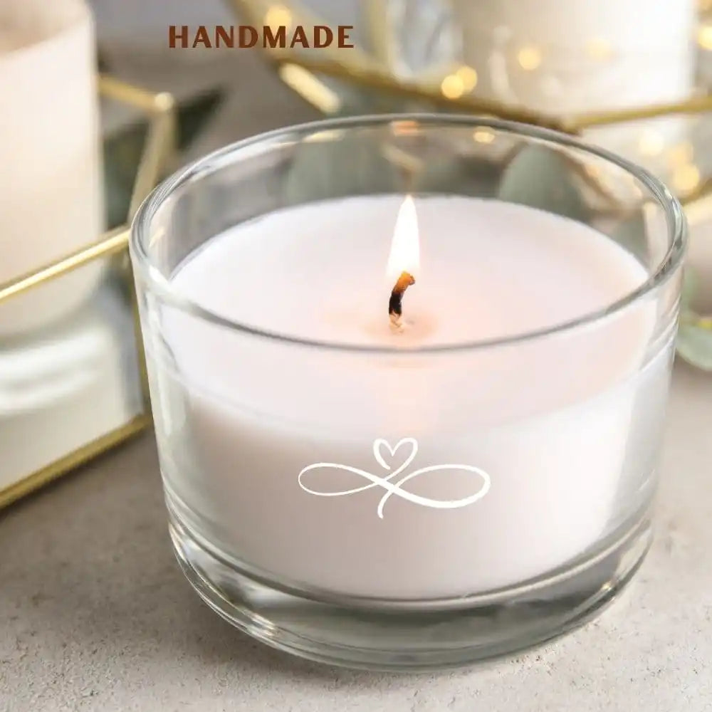 Handmade candle in a glass container with a small logo on a light background