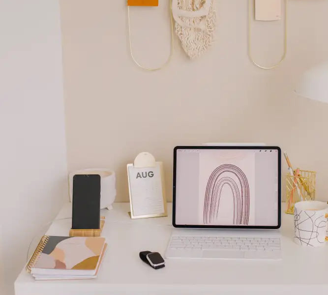 White tablet displaying a minimalist rainbow illustration on its screen